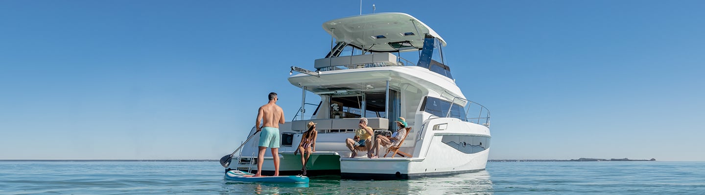 people using water toys around aquila power catamaran